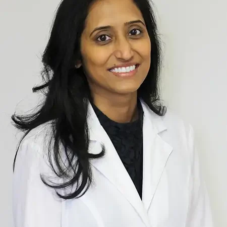 Dr. Anupama Vurugonda in a white coat, smiling, representing experienced general dentistry and patient-focused care at Midwest Family Dental Care.