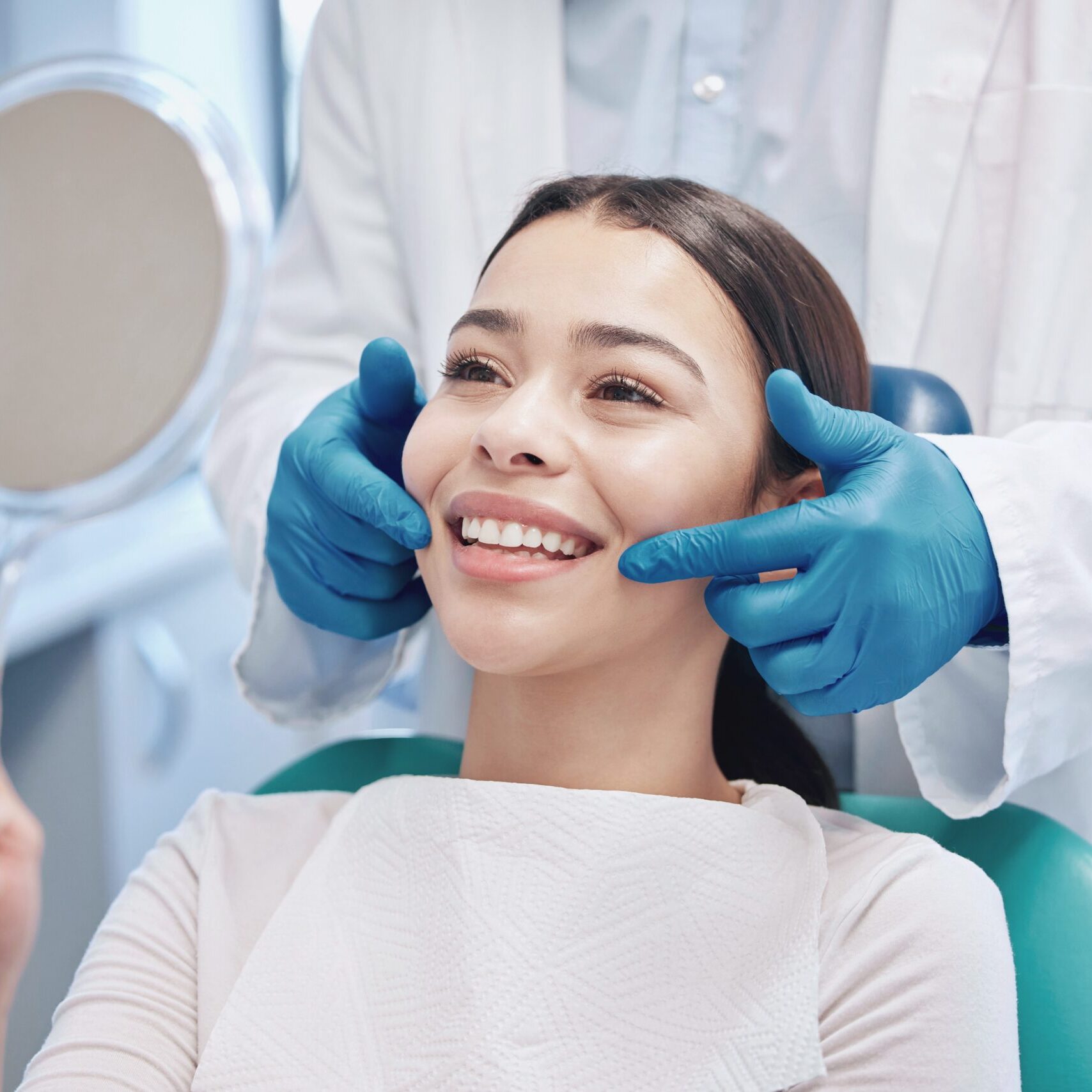 Patient smiling in dental chair as dentist examines teeth and gums, emphasizing cosmetic dentistry services at Midwest Family Dental Care in Kokomo.
