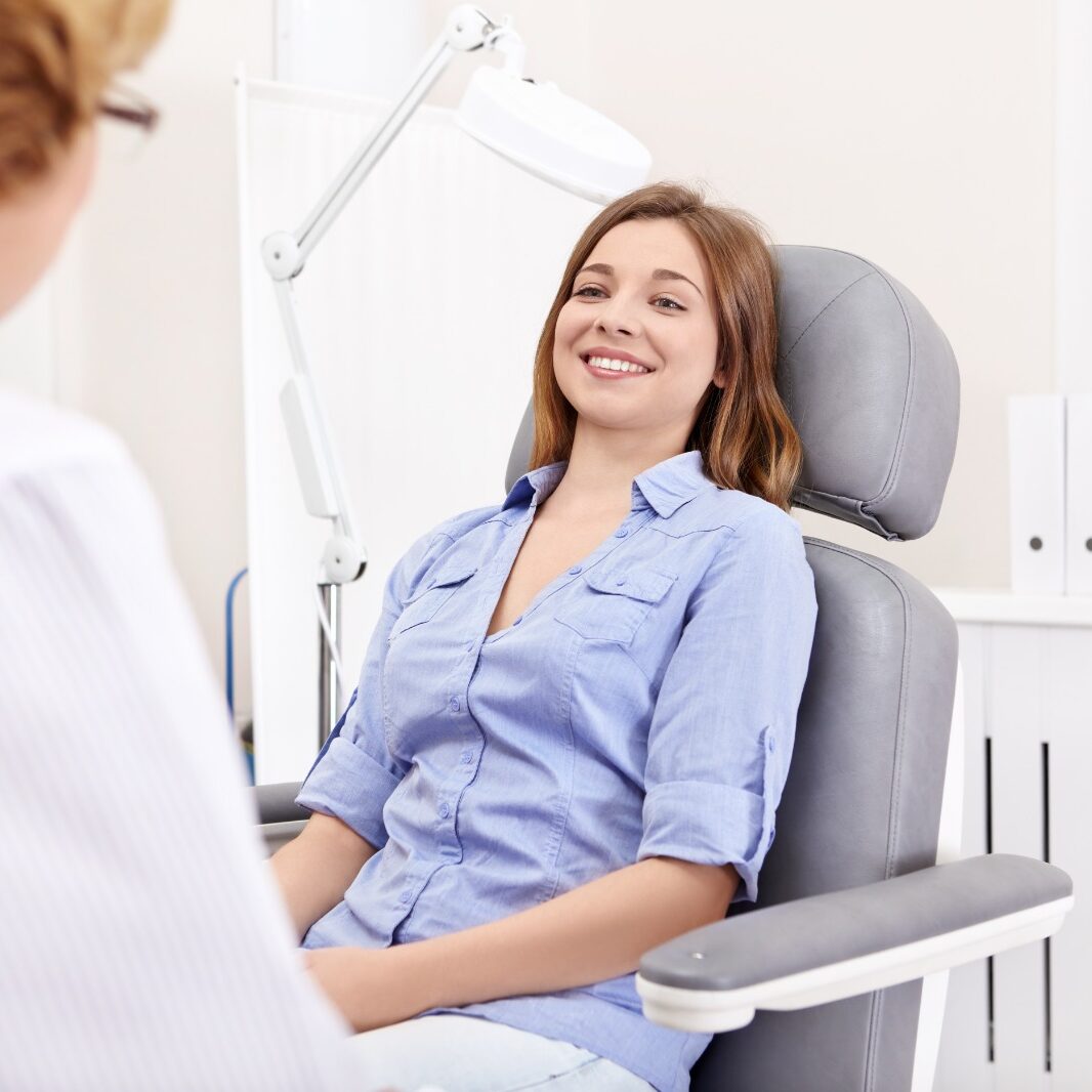 Smiling young woman seated in dental chair, illustrating patient-centered care at Midwest Family Dental Care in Kokomo, IN.